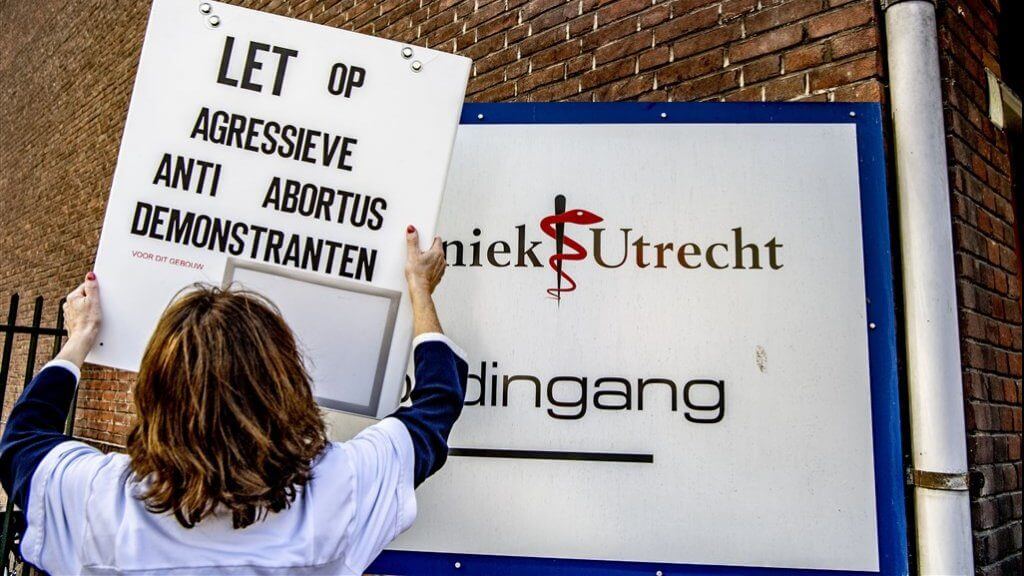 Een bord waarschuwt voor agressieve anti-abortusdemonstranten bij de kliniek in Utrecht