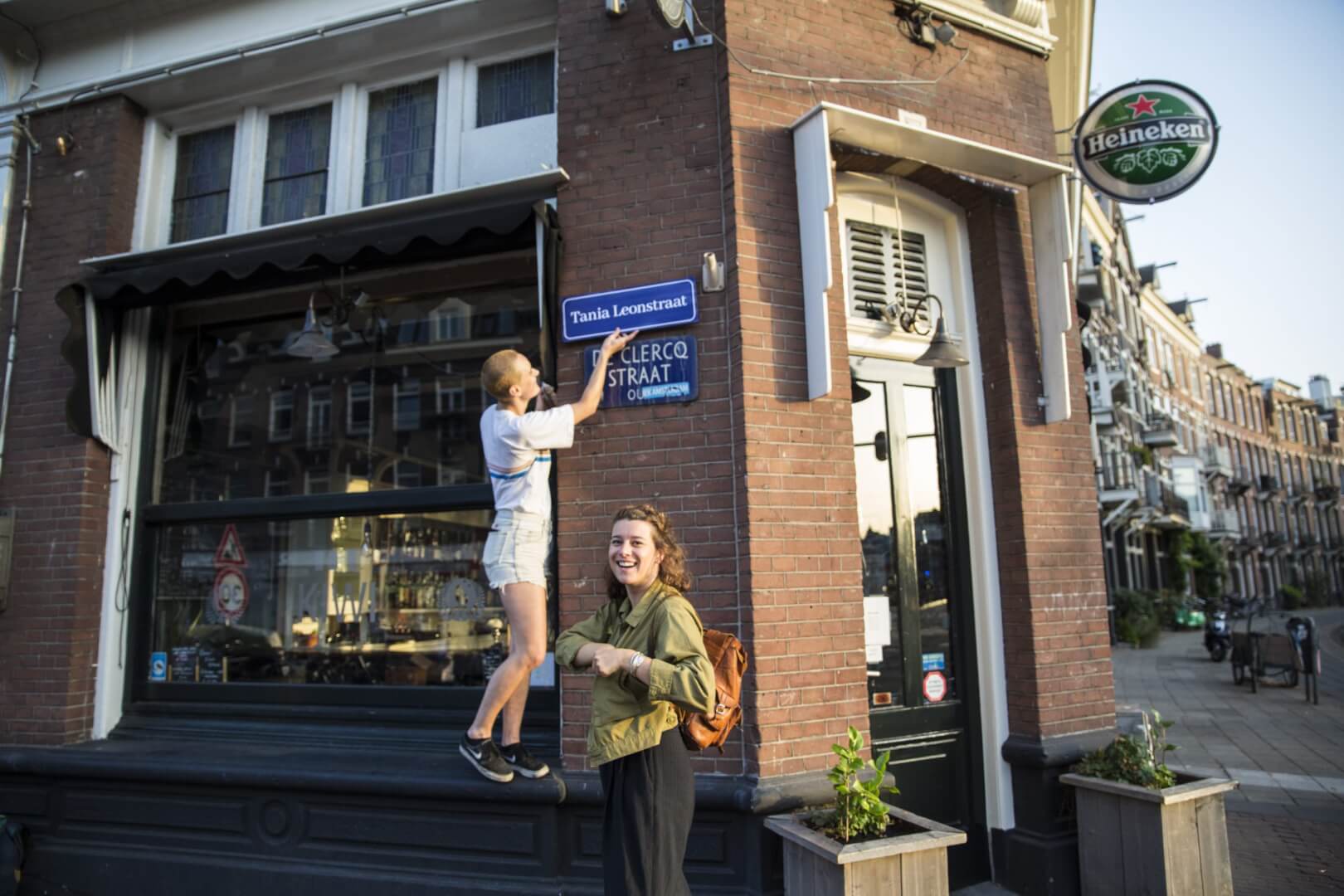 Actievoerders plaatsen een straatnaambord voor Tania Leon